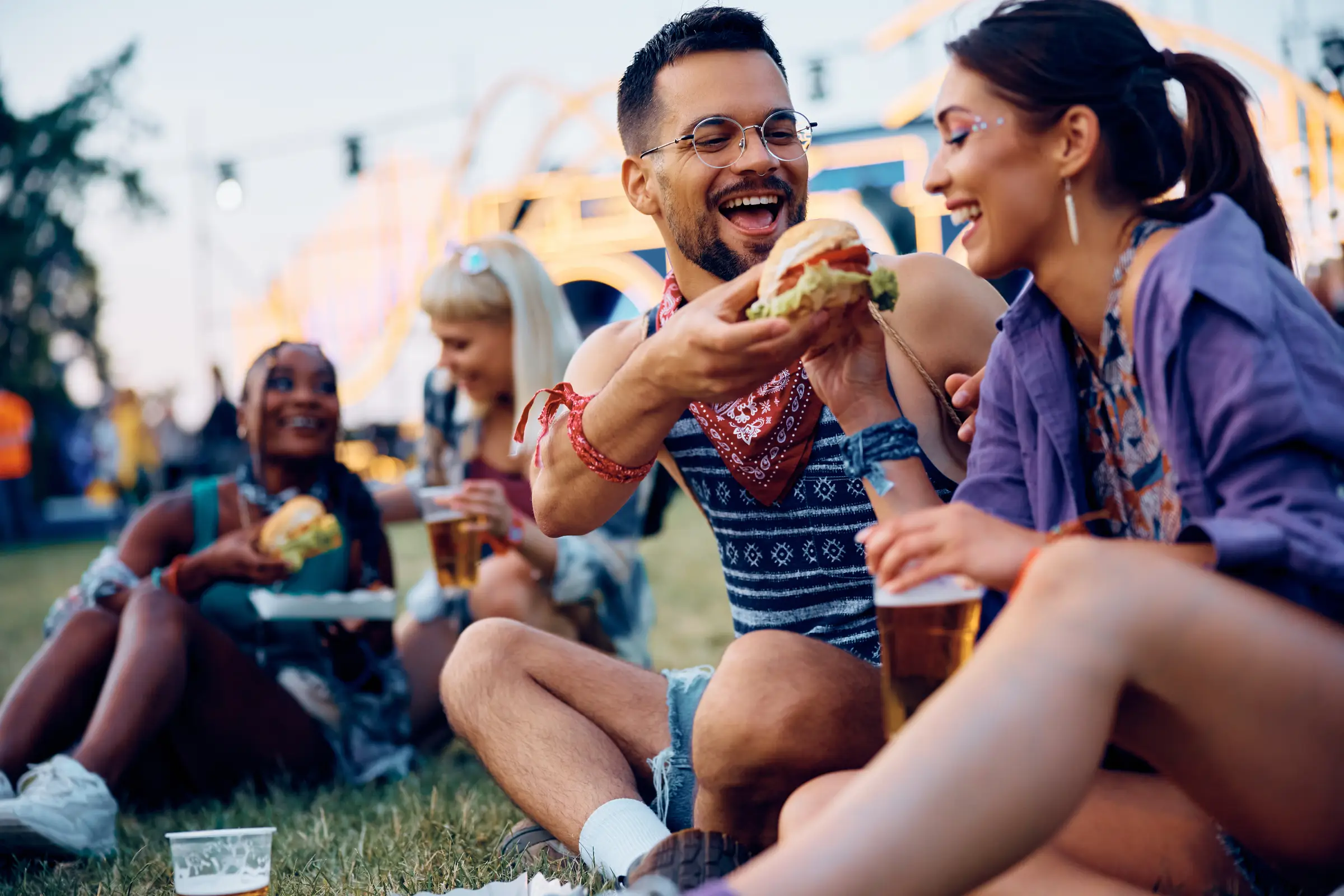 Freunde sitzen auf der Wiese und genießen das Festival